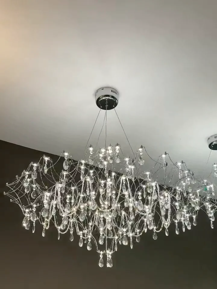 A crystal chandelier switched on, photographed from below in the showroom