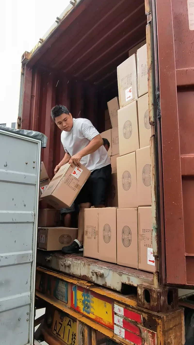 Cartons being passed through the open container door during loading